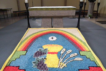 Tapis de fleurs avec le motif du calice à Corpus Christi dans une église de la paroisse.