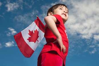 Une petite fille tenant le drapeau canadien à la Fête du Canada.