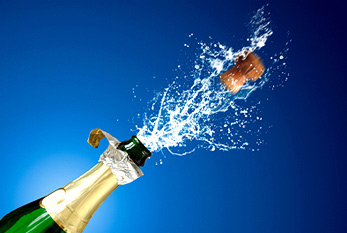 Un bouchon de champagne et champagne éclaboussures d'une bouteille de champagne