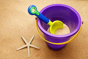 Seau de sable avec une pelle sur la plage.