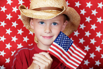 Garçon avec un chapeau de cow-boy et le drapeau américain sur le Jour du drapeau.