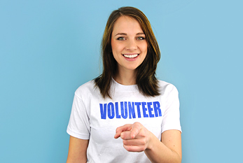 Une femme avec un t-shirt blanc, sur le «Volunteer» (anglais pour «volontaires») signifie.