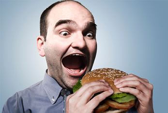 Un homme de manger un hamburger sur la Journée sans régime: pas de régime, pas de problème!