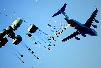 Un avion parachutages palettes d'eau et de la nourriture sur une zone sinistrée.