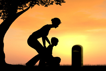 Veuve avec son enfant sur la tombe de son mari.