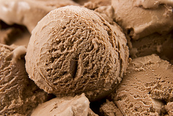 Gros plan d'une boule de glace au chocolat sur plus de glace au chocolat.