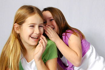 Deux petites filles rient d'une blague.