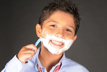 Peut commencer calme dans le pas-barbe-journée, car il n'a probablement jamais eu une barbe: un garçon qui se rase.